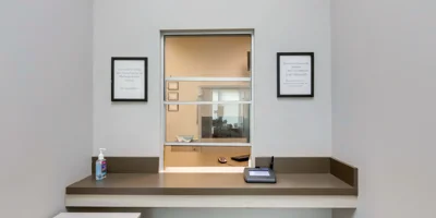 Reception window with signs and a bin.