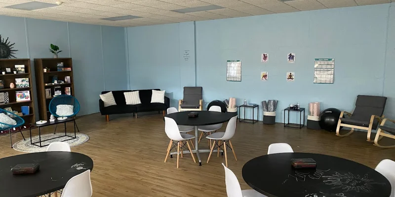 Group therapy room with round tables, chairs and blue walls.