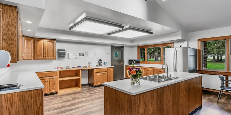 Spacious kitchen with wooden cabinets and an island sink.