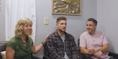 People seated in an office with wall decor.