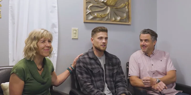 People seated in an office with wall decor.