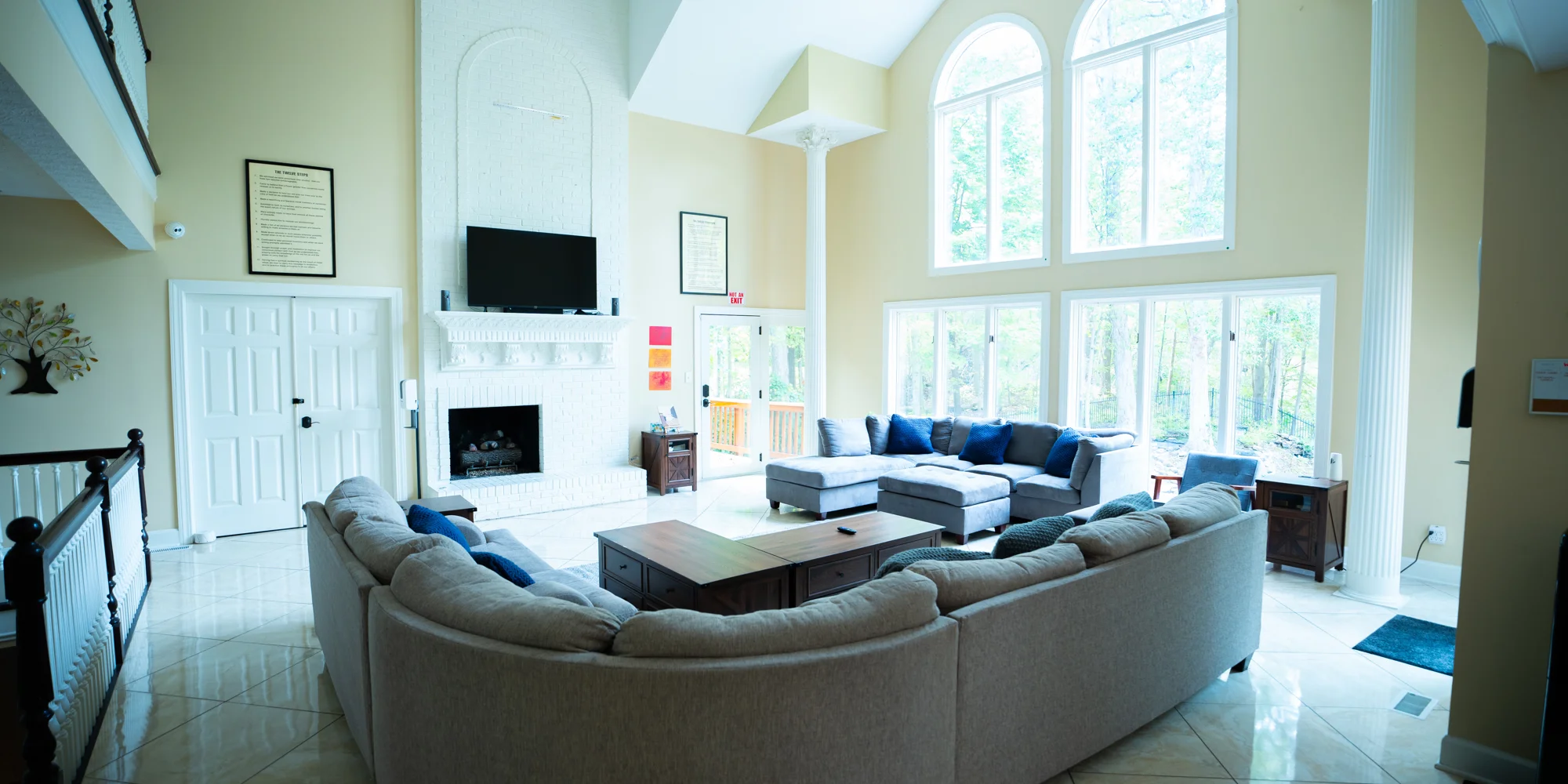 Bright living room with sectional couches and tall windows