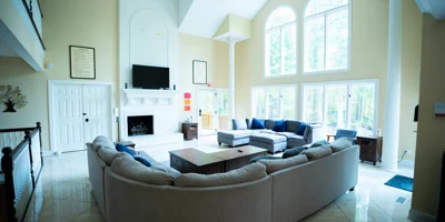 Bright living room with sectional couches and tall windows