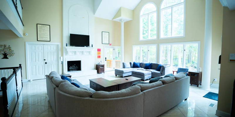 Bright living room with sectional couches and tall windows