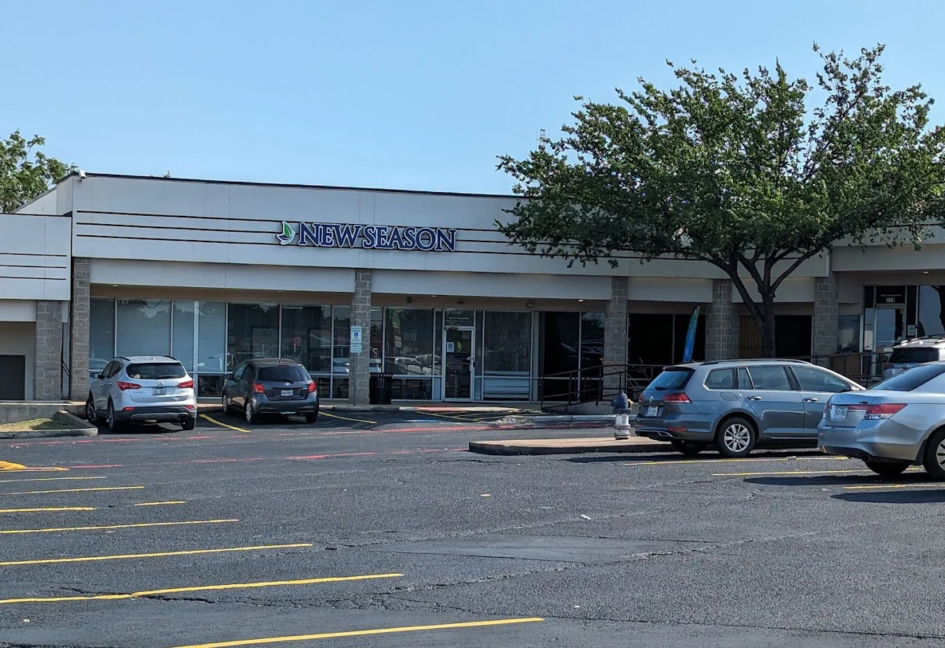 Facility exterior with parking lot and trees.