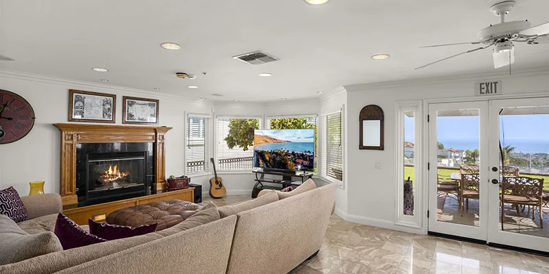 Cozy living room with fireplace, sectional couch, and ocean view.