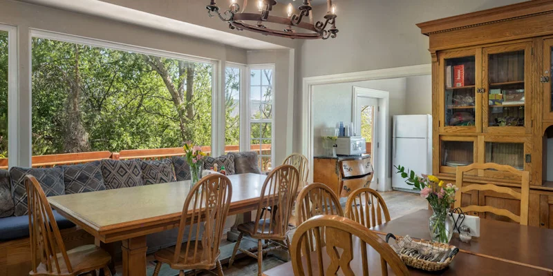 Dining area with a large window, tables and chairs.
