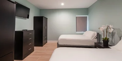 Shared bedroom with two beds, furniture, and a TV.