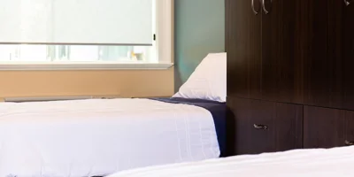 Dorm-style bedroom featuring two single beds and a dresser.