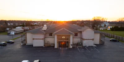 Rehab center exterior at sunset with large parking area