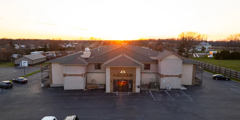 Rehab center exterior at sunset with large parking area