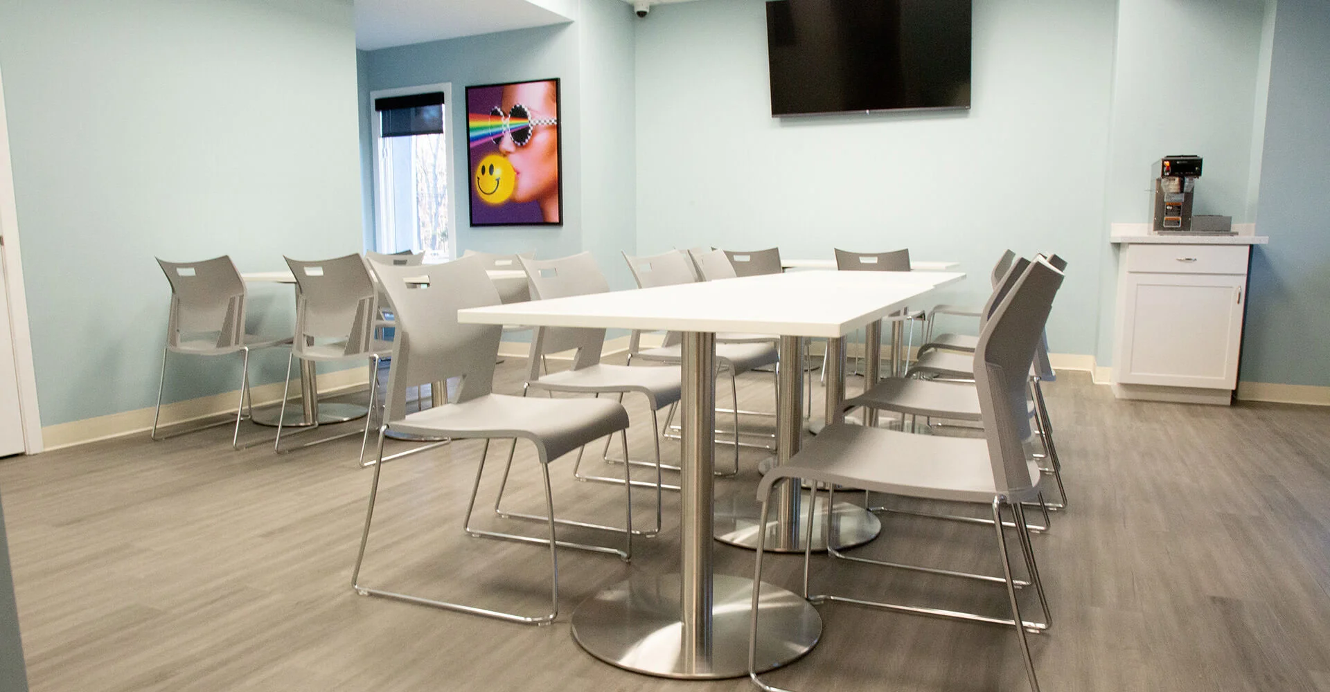 Dining area with tables, chairs and a TV.