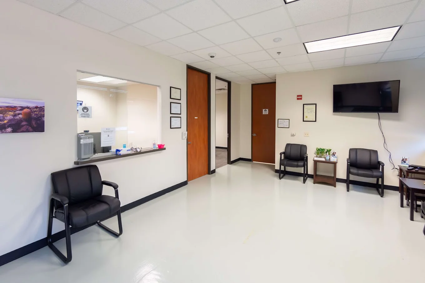 A reception area with seating and a check-in window at Symetria Recovery