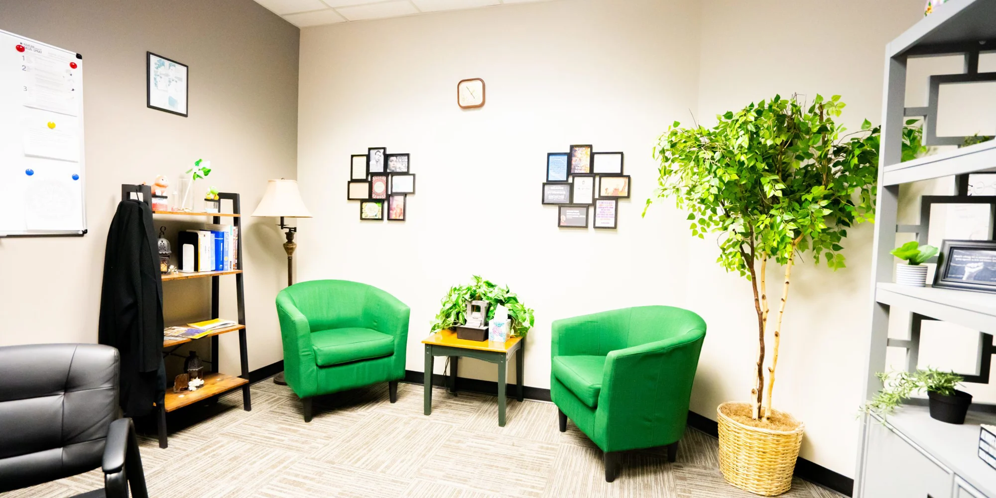 A well-lit office space with green chairs and decorative wall art.