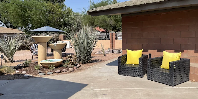 Outdoor area with seating, umbrella, and a mini-fountain.