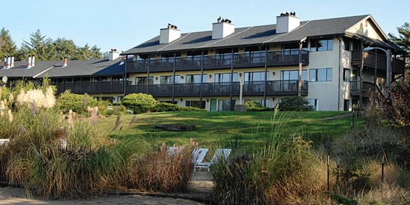 A rehab facility with balconies and a well-maintained lawn.