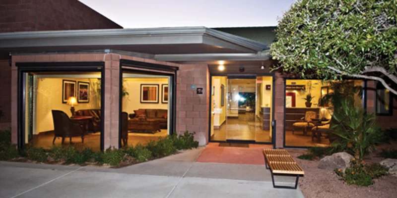 Paved outdoor patio with seating and greenery.