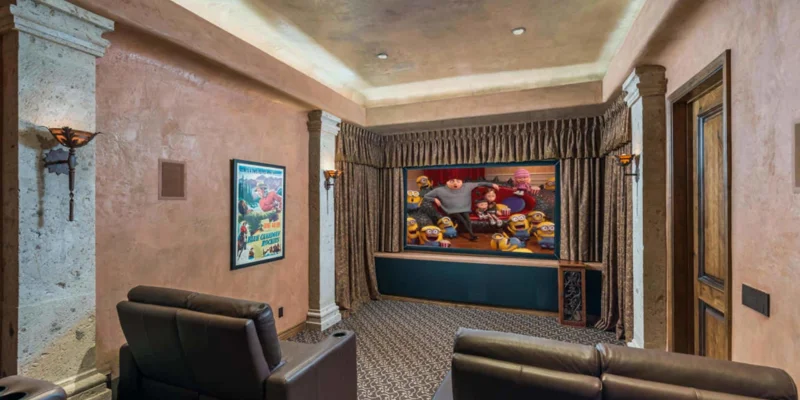 Cinema with a few couches facing a screen.