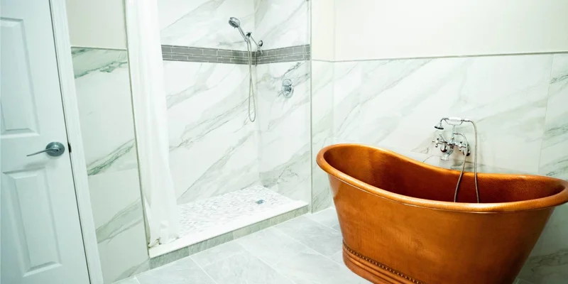 Luxurious bathroom with a copper bathtub and marble walls.