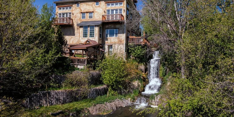 Facility exterior with a waterfall and outdoor lounge.