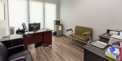 Medical office with a desk, chair, and equipment.