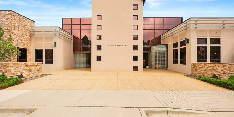 Modern building entrance with glass panels and a beige facade.