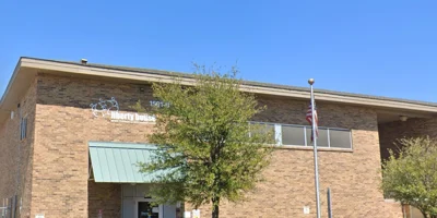 Entrance of a brick detox facility with a large sign and well-maintained landscaping.