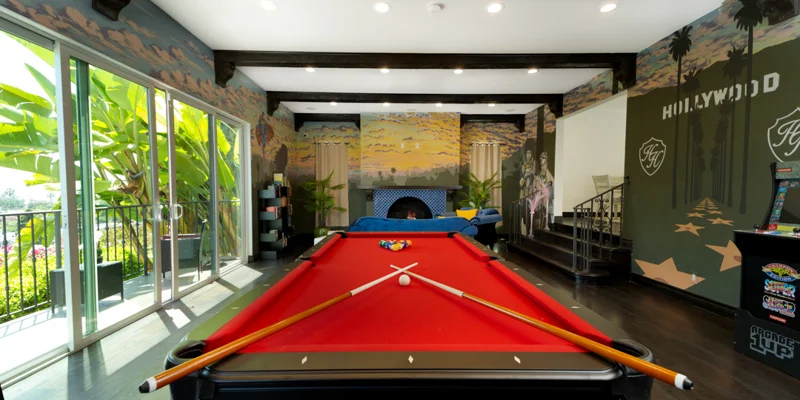 Game room with red pool table and Hollywood-themed wall art