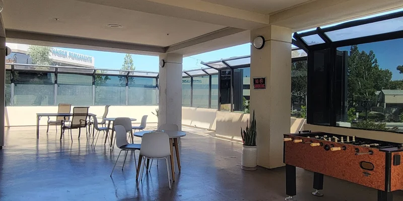 An open-air patio with tables, chairs, and a foosball table