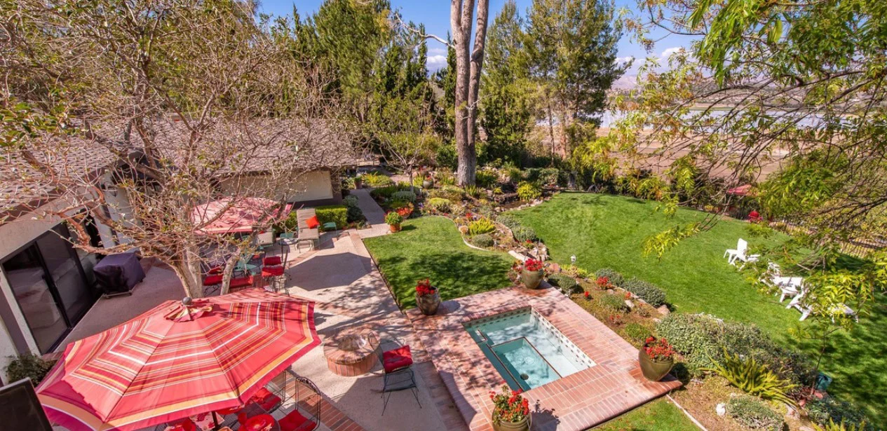 Facility backyard with a spa and seating.