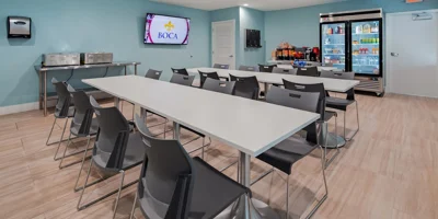 Dining area with seating, a large TV, and drink coolers.