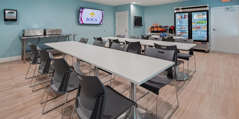 Dining area with seating, a large TV, and drink coolers.