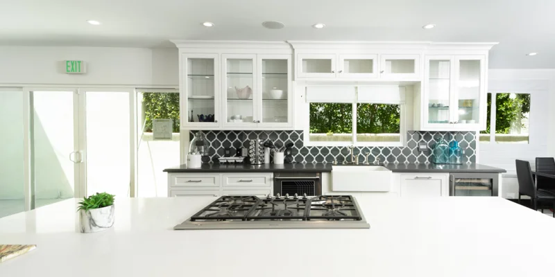 White modern kitchen with island and gas cooktop