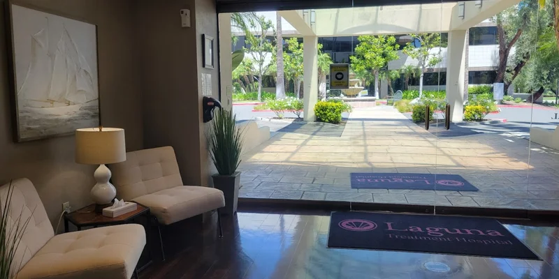 An entryway with glass doors leading to an outdoor courtyard