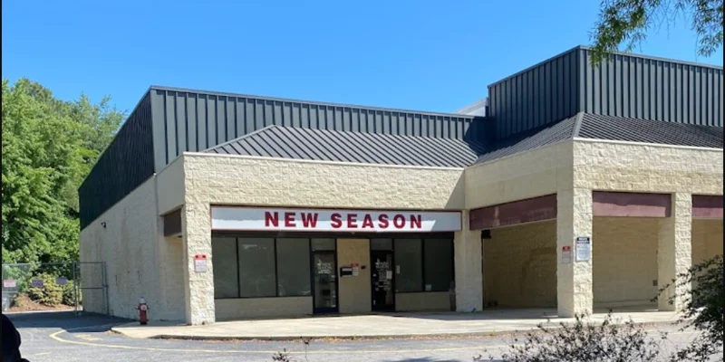 Facility exterior with glass door entrance and parking.