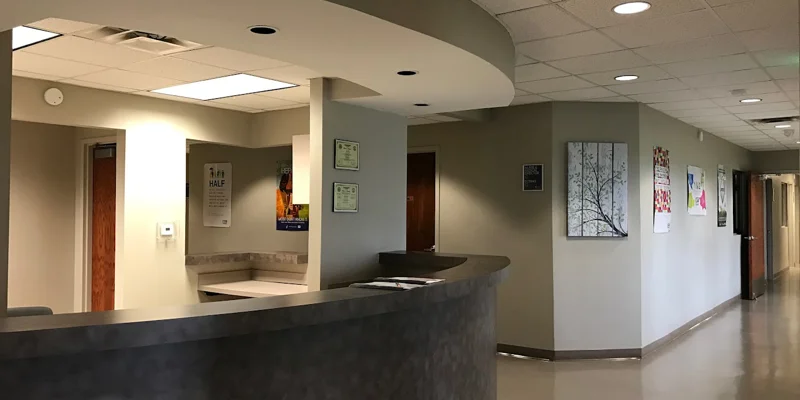 Reception area with a desk leading to a hallway.