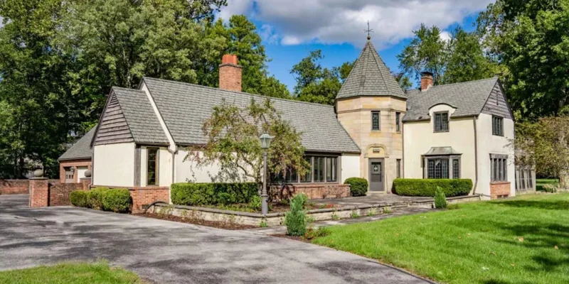 Tudor-style rehab facility with lush greenery and a peaceful setting.