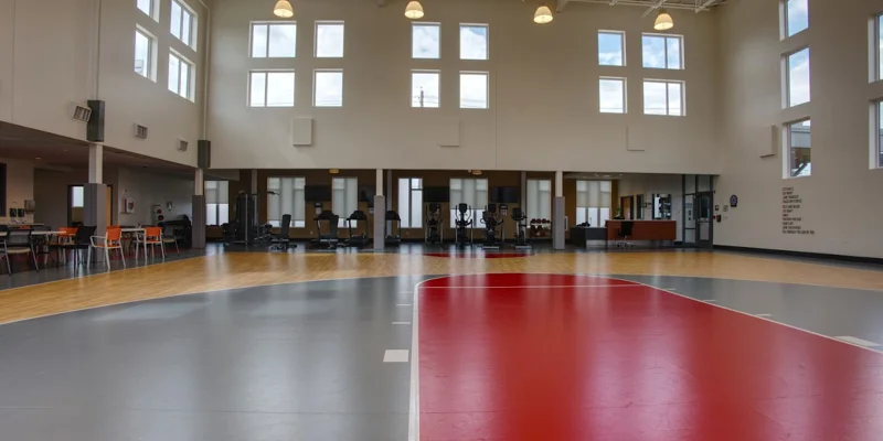 Open gym with equiptment and basketball court in the space.