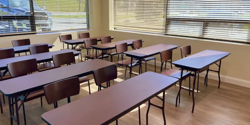 Classroom with desks and chairs by windows