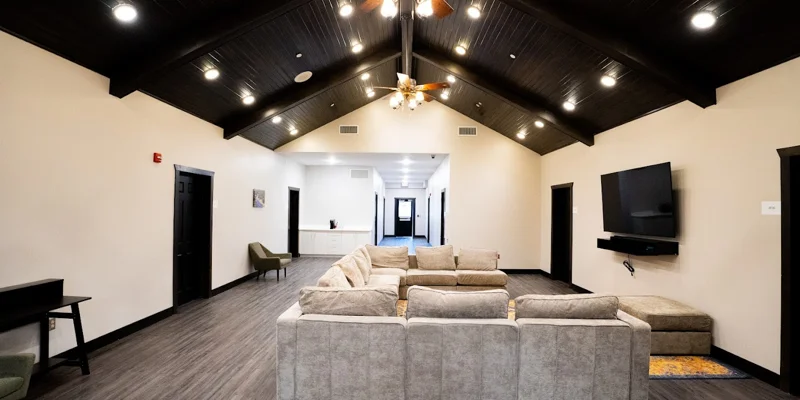 Rehab facility lounge with vaulted ceilings and soft seating.