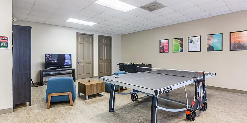 Recreation room with a ping pong table, TV, and seating area.