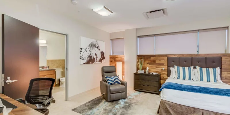 Private bedroom with bed, armchair and a in-suite bathroom.
