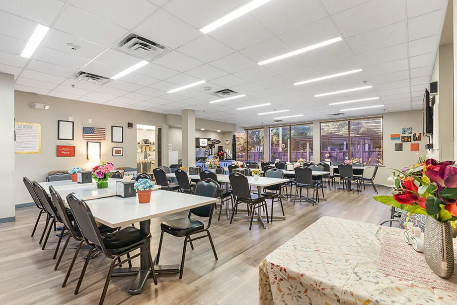 Spacious dining area with tables, chairs, and floral centerpieces