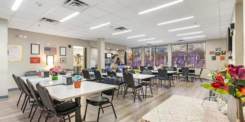 Spacious dining area with tables, chairs, and floral centerpieces