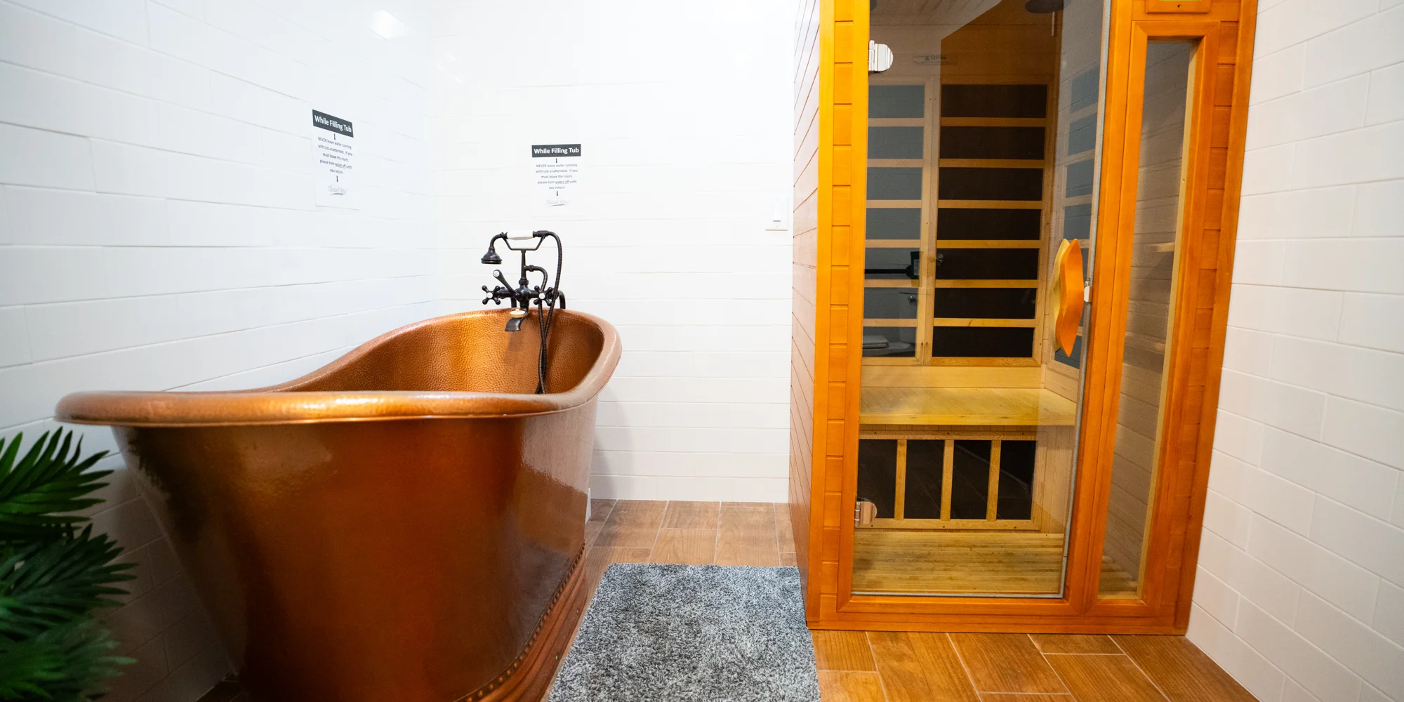 A copper bathtub next to a sauna in a spa-like setting.