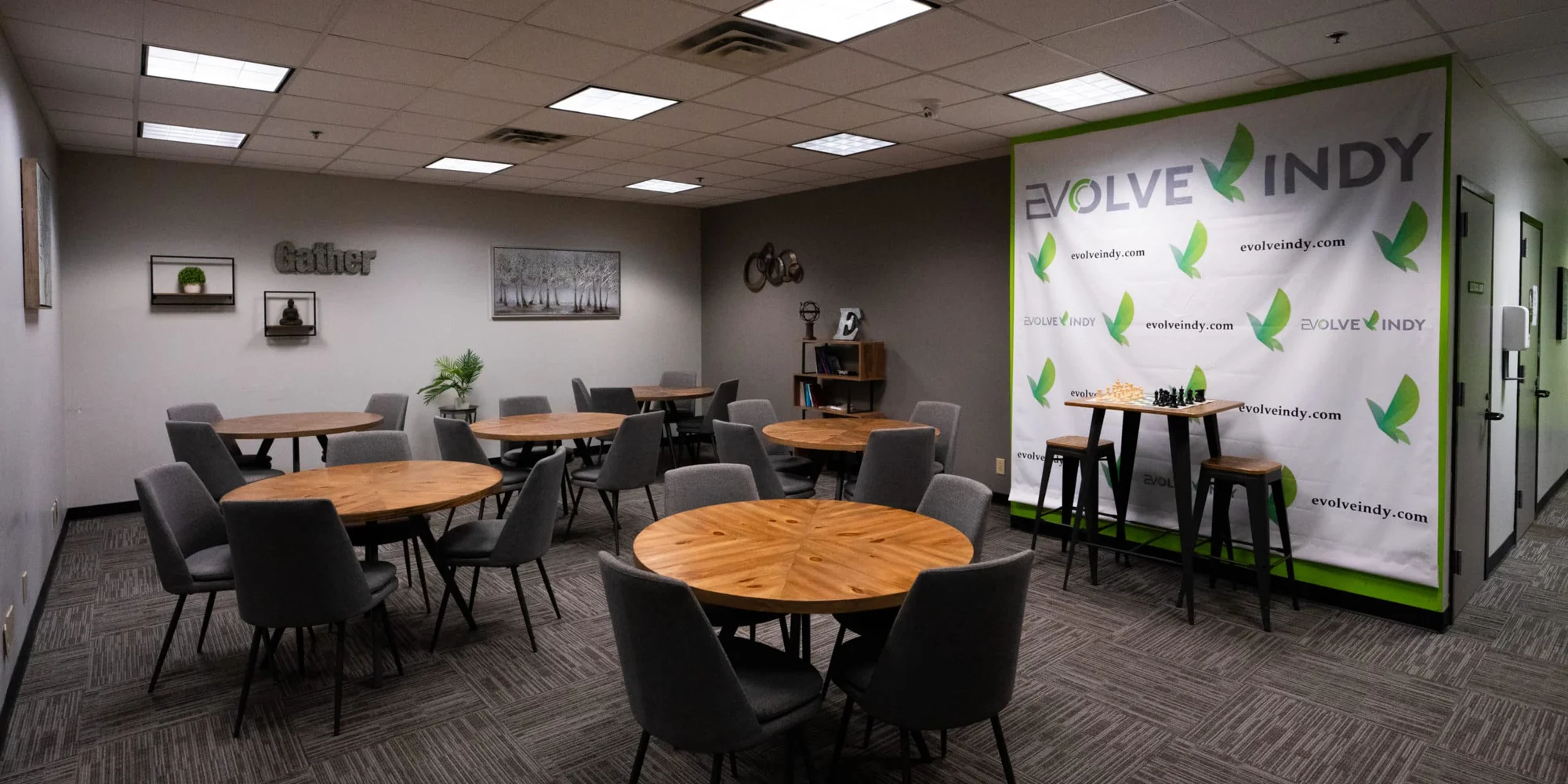 A communal dining area with black chairs and tables.