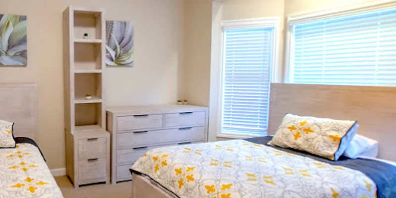 Bedroom with two beds and a dresser.