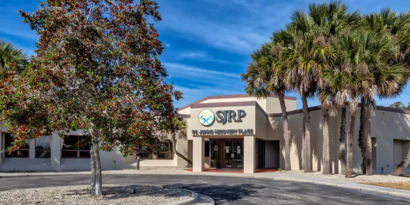 Rehab facility exterior with palm trees.