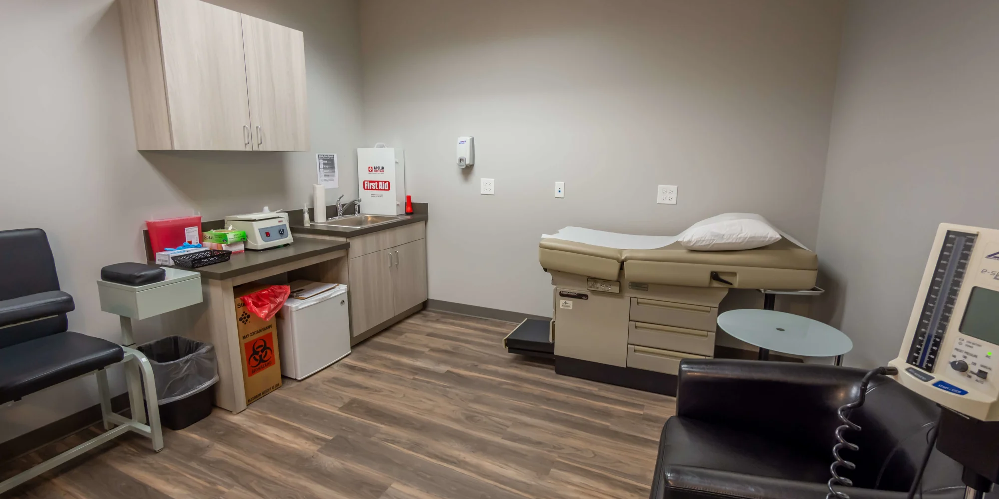 Medical exam room with an examination table and organized supplies.