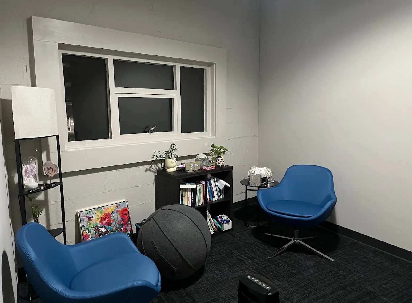 A therapy room with blue chairs and modern decorations.